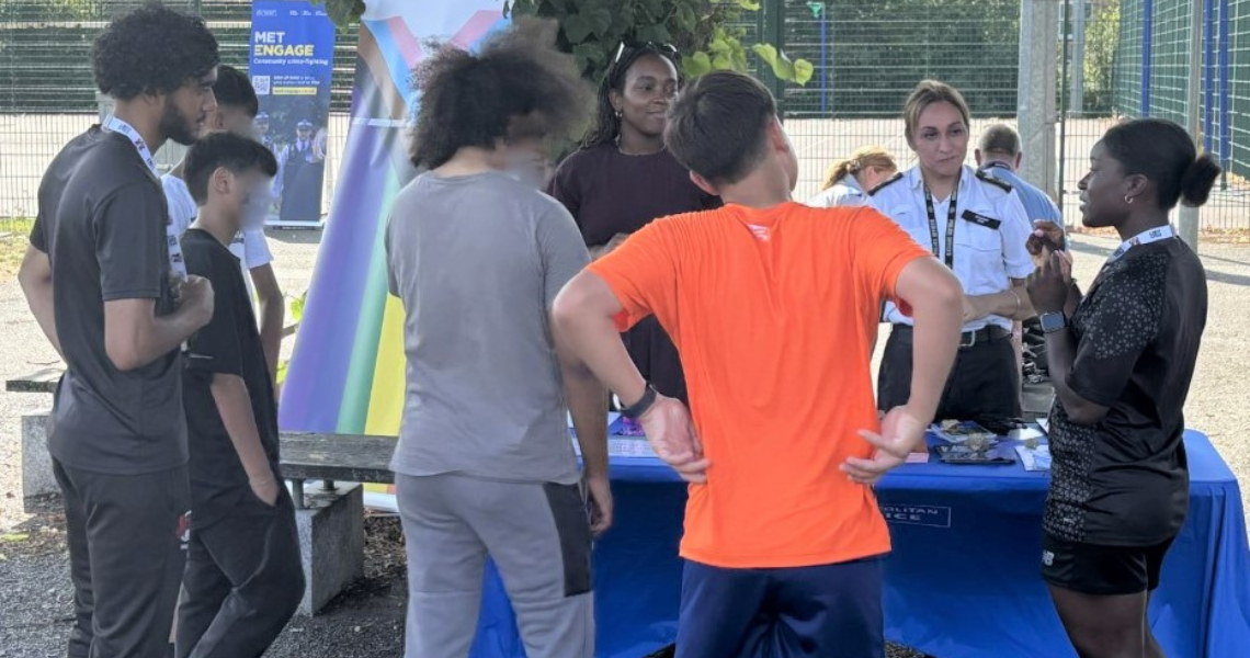 Police officers engage with young people around a trestle table.