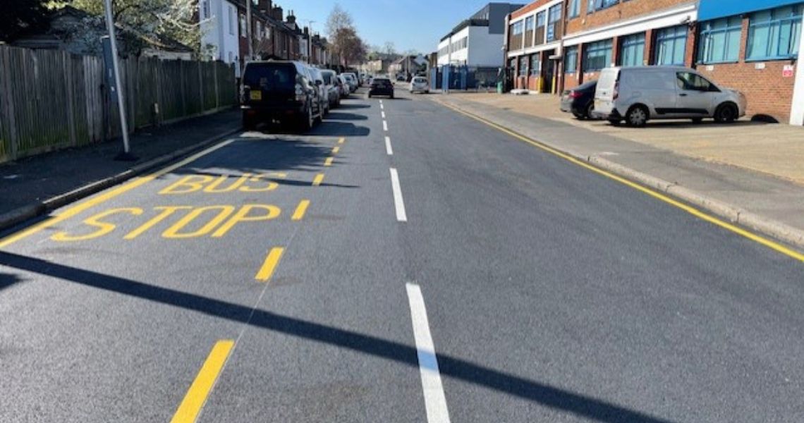 A newly resurfaced road with freshly painted road markings.