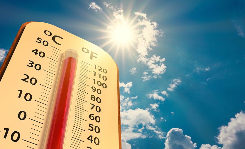 Thermometer on blue sky with sun shining 