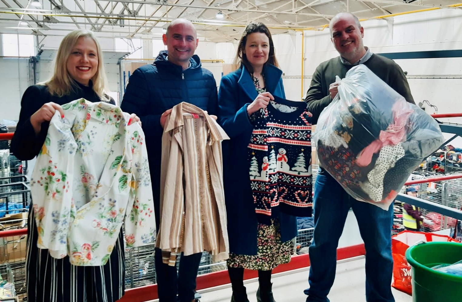 People displaying donated clothes