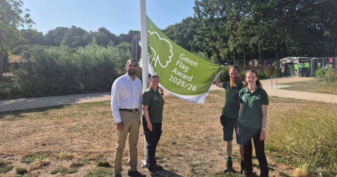 Councill leader Kam Rai and members of the Redbridge Parks team admire one of the awarded Green Flags